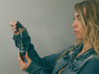 אישה מחזיקה בקבוקון שמן CBD